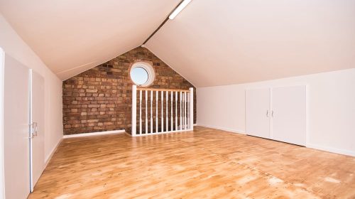 Loft-Room-Conversion-with-Circular-Window-and-Exposed-Bricks-UK